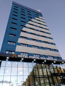 a building with a hotelential dog cleaners sign on it at Hotel Portal dos Devotos in Aparecida