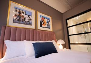 a bedroom with a large bed with a blue pillow at Boutique 50 in Glasgow