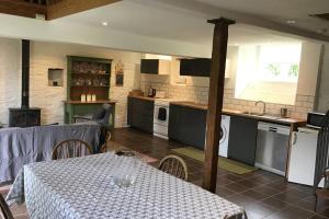 a kitchen with a table and a kitchen with a table and a table at La Porcherie at La Grande Houssaye in Villiers-Fossard