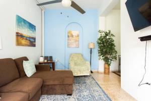 Comfort, Location, and Great Price في ريو غراندي: غرفة معيشة مع أريكة بنية والجدار الأزرق
