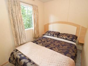 a small bedroom with a bed and a window at Vista in Moelfre