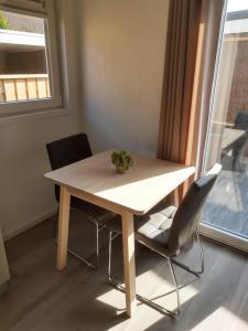 een tafel en 2 stoelen in een kamer met een raam bij Vakantiechalet "Huisje onder de Toren" in Oostkapelle