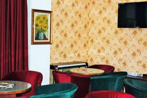 プレデアルにあるPensiunea Drumetulの赤い椅子とテーブル、テレビ付きのレストラン