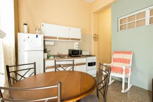 a kitchen with a table and a kitchen with a refrigerator at Comfortable and Affordable Deal Close to Beach and Rainforest in Rio Grande