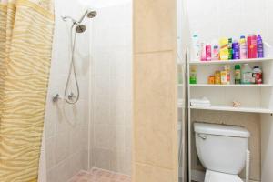 a bathroom with a shower and a white toilet at Comfortable and Affordable Deal Close to Beach and Rainforest in Rio Grande