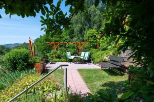 - un jardin avec un banc, une table et des chaises dans l'établissement Ferienwohnung Hauk, à Laudenbach