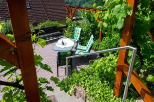 d'une terrasse avec des chaises et une table dans le jardin. dans l'établissement Ferienwohnung Hauk, à Laudenbach