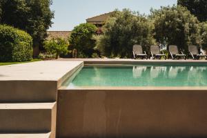 a swimming pool with chairs in a yard at Casa di Melo - Organic Country Hotel in Cassibile