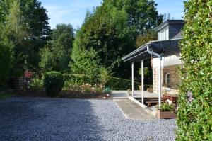 un jardin avec une maison et une allée en gravier dans l'établissement Cottage Marie-Henriette, à Spa