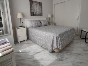 1 dormitorio blanco con 1 cama y 2 mesitas de noche en Santa Justa Sevilla Nervion Buhaira Centro, en Sevilla