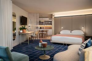 um quarto de hotel com uma cama e uma sala de estar em Home Suite Hotels Sea Point em Cidade do Cabo