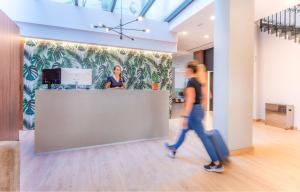 a woman walking past a counter in an office at DWO Nopal in Puerto de la Cruz +37 photos