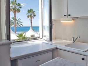 eine Küche mit einem Fenster mit Blick auf den Strand in der Unterkunft Medusa Apartment - Piazza 1 in Finale Ligure