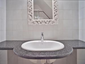 ein weißes Waschbecken im Bad mit Spiegel in der Unterkunft Medusa Apartment - Piazza 1 in Finale Ligure