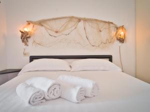 ein weißes Bett mit Handtüchern darüber in der Unterkunft Medusa Apartment - Piazza 1 in Finale Ligure