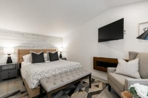 um quarto com uma cama, uma televisão e um sofá em Le ChiK by Gestion ELITE em Mont-Tremblant