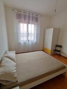 duże łóżko w pokoju z oknem w obiekcie White beach Le Castella w mieście Le Castella