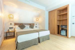 a bedroom with a large bed and a fireplace at DWO Nopal in Puerto de la Cruz