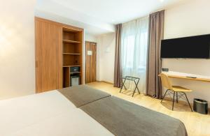 a hotel room with a large bed and a desk at DWO Nopal in Puerto de la Cruz