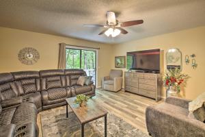 a living room with a couch and a flat screen tv at Hot Springs House with Spacious Deck and Grill! in Hot Springs Village