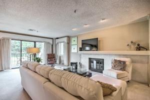 a living room with a large couch and a fireplace at Luxe Monkey Island Condo with Golf Course Views! in Monkey Island