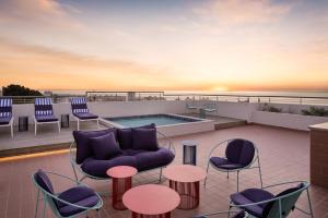 a rooftop patio with furniture and a swimming pool at Home Suite Hotels Sea Point in Cape Town