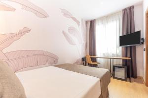 a hotel room with a bed and a tv at DWO Nopal in Puerto de la Cruz