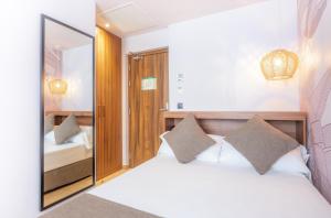 a bedroom with a white bed and a mirror at DWO Nopal in Puerto de la Cruz