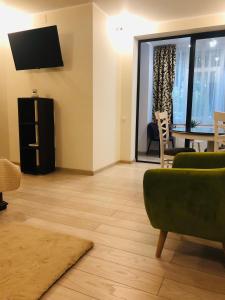 a living room with a tv and a table and chairs at APARTAMENT PARK in Brăila