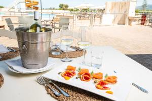 a plate of food on a table with wine glasses at Salvapiano Holiday Ranch in Riotorto