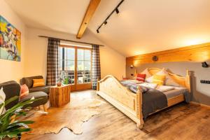 1 dormitorio con cama de madera y sofá en Desiree`s Dahuim en Bad Hindelang