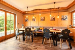 een eetkamer met een grote houten tafel en stoelen bij Desiree`s Dahuim in Bad Hindelang