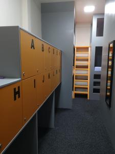 a row of lockers in a room with a ladder at Birmingham Central Backpackers in Birmingham