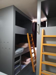 Cette chambre dispose de lits superposés avec une échelle et des lits superposés. dans l'établissement Birmingham Central Backpackers, à Birmingham