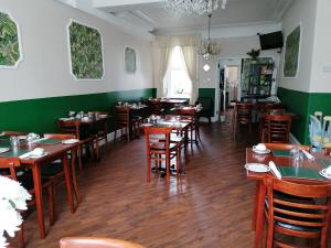 a restaurant with wooden tables and chairs and green walls at Birchhouse in Blackpool