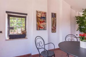 ein Esszimmer mit einem Tisch, Stühlen und einem Fenster in der Unterkunft Torripa Group - Trastevere in Rom
