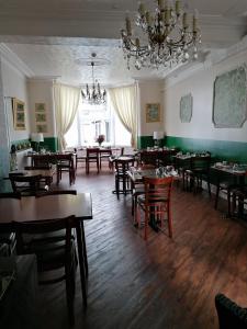 une salle à manger avec des tables et des chaises ainsi qu'un lustre dans l'établissement Birchhouse, à Blackpool