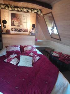 - une chambre avec un grand lit et des draps violets dans l'établissement La maison de Justine, à Cassaniouze