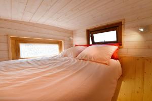 een bed in een kleine kamer met een raam bij Tiny Côte d’Opale in Audresselles