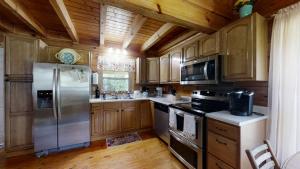 a kitchen with wooden cabinets and a stainless steel refrigerator at Yellow Cabin on the River cabin in Newport