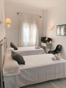 a bedroom with a bed, chair, and nightstand at Hotel Doña Blanca in Seville