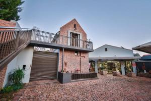 a brick house with a balcony and a garage at Upper Room @thegallery in Bloemfontein