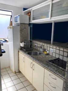 uma cozinha com um lavatório e um frigorífico em Studio Flat no Resort Gavoa - frente a Coroa do Avião em Igarassu