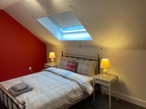 a bedroom with a bed and a skylight at Stylish Loft Apartment in central Perth in Perth