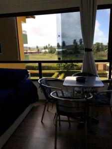 um quarto com uma mesa e cadeiras e uma janela em Studio Flat no Resort Gavoa - frente a Coroa do Avião em Igarassu