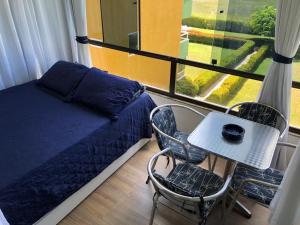 um quarto com uma cama e uma mesa com cadeiras em Studio Flat no Resort Gavoa - frente a Coroa do Avião em Igarassu