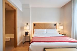 ein Schlafzimmer mit großem Bett und ein Badezimmer in der Unterkunft Catalonia Eixample 1864 in Barcelona