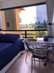 um quarto com uma cama, uma mesa e uma janela em Studio Flat no Resort Gavoa - frente a Coroa do Avião em Igarassu