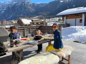 tres chicas sentadas en una mesa comiendo comida en una mesa en Monika-Mellau Appartements en Mellau
