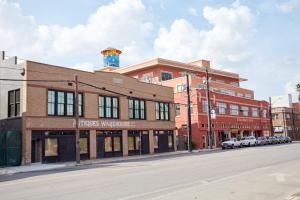 a brick building on a street with cars parked in front at Sonder Antiques Warehouse in San Antonio